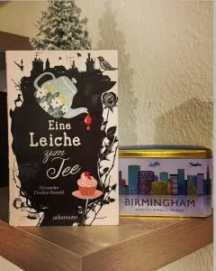 Das Cover des Buchs zeigt eine Teekanne aus der Bluttropfen auf einen Muffin fallen.