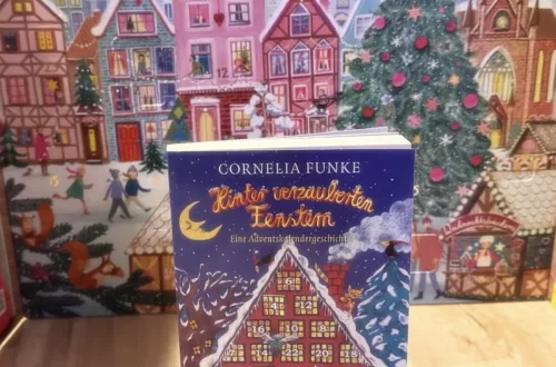 Das Buch steht vor einem Adventskalender. Auf dem Cover ist ebenfalls ein Adventskalender in Form eines Hauses zu sehen.
