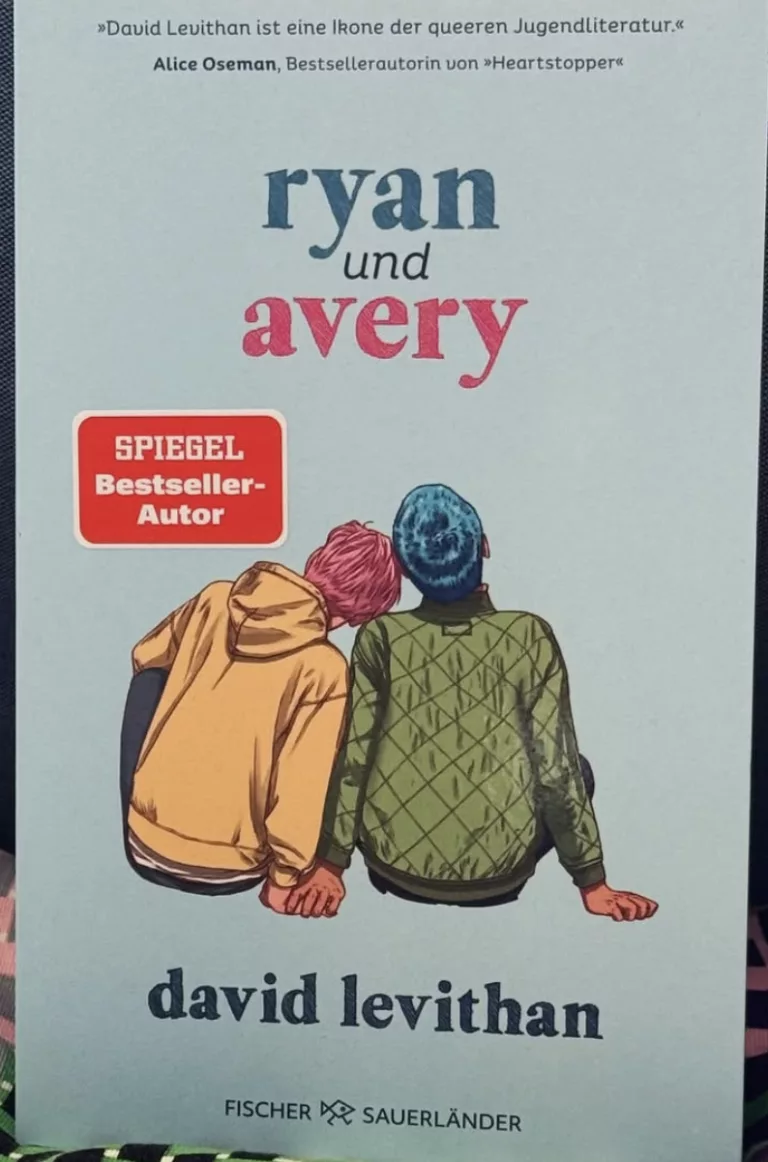 Buchcover von „Ryan und Avery“ von David Levithan. Vor einem hellblauen Hintergrund zeigt eine Illustration von hinten zwei Teenager, die nebeneinander sitzen: Einer trägt einen gelben Hoodie und lehnt den Kopf an die Schulter des anderen, der eine olivgrüne Steppjacke trägt. Der Titel steht in blauer und pinker Schrift darüber, ergänzt durch ein Lobzitat von Alice Oseman und das Logo des Fischer Sauerländer Verlags.